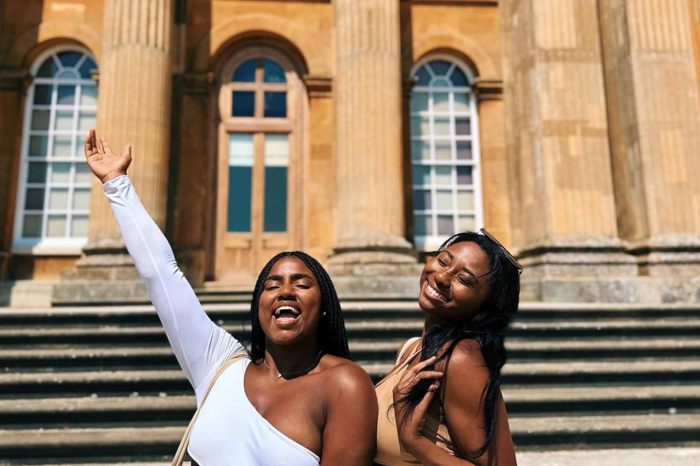 Two FSU students smiling with arms raised in London.