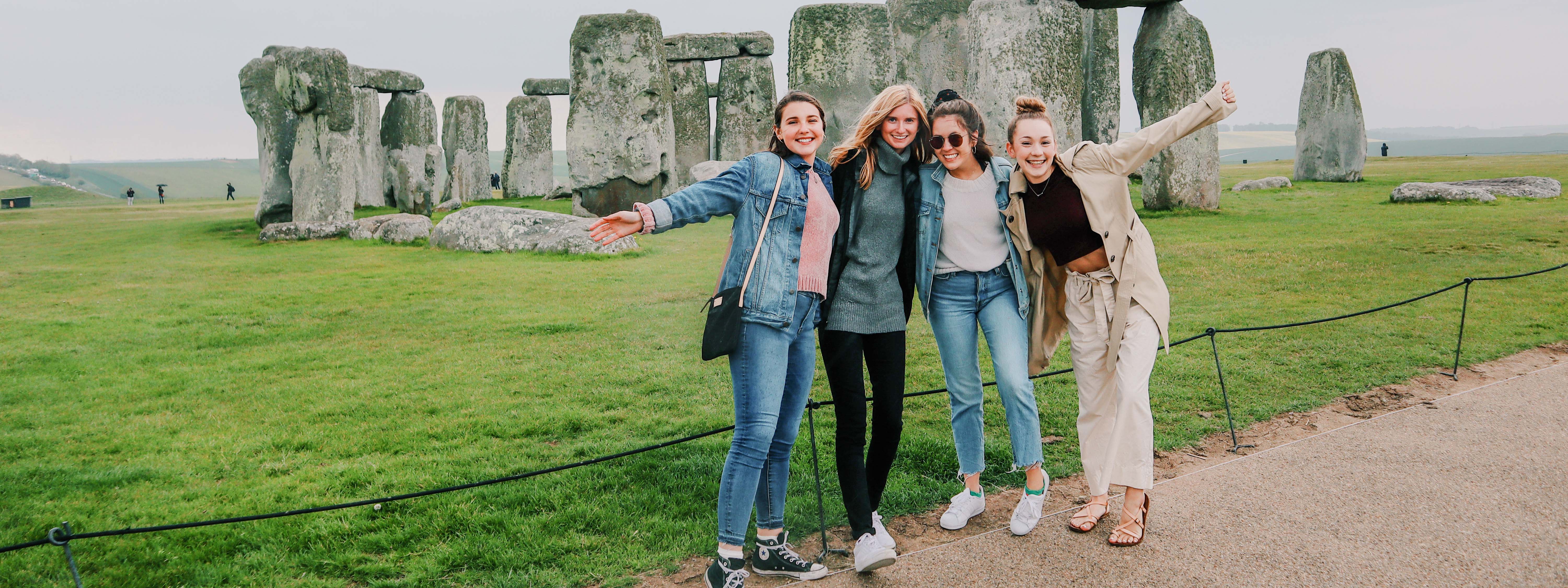 Students excitedly posing in front of Stonehenge in England.