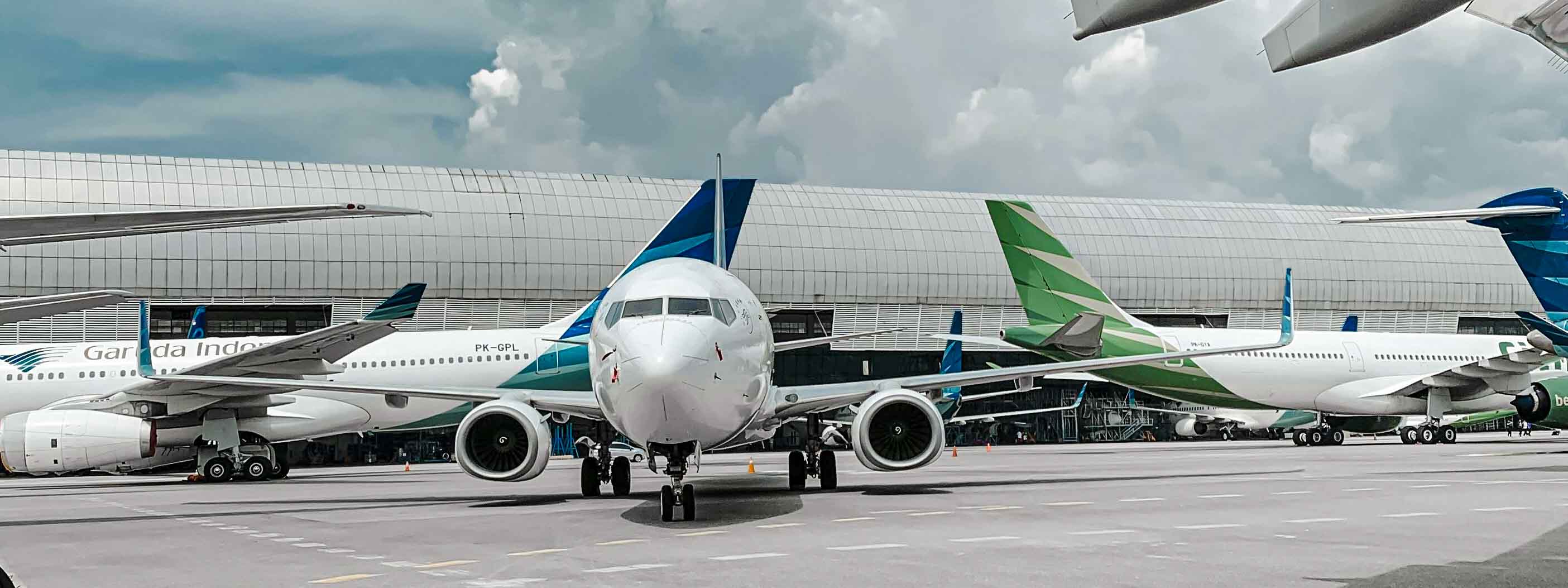 Planes parked next to each other at airport gates.