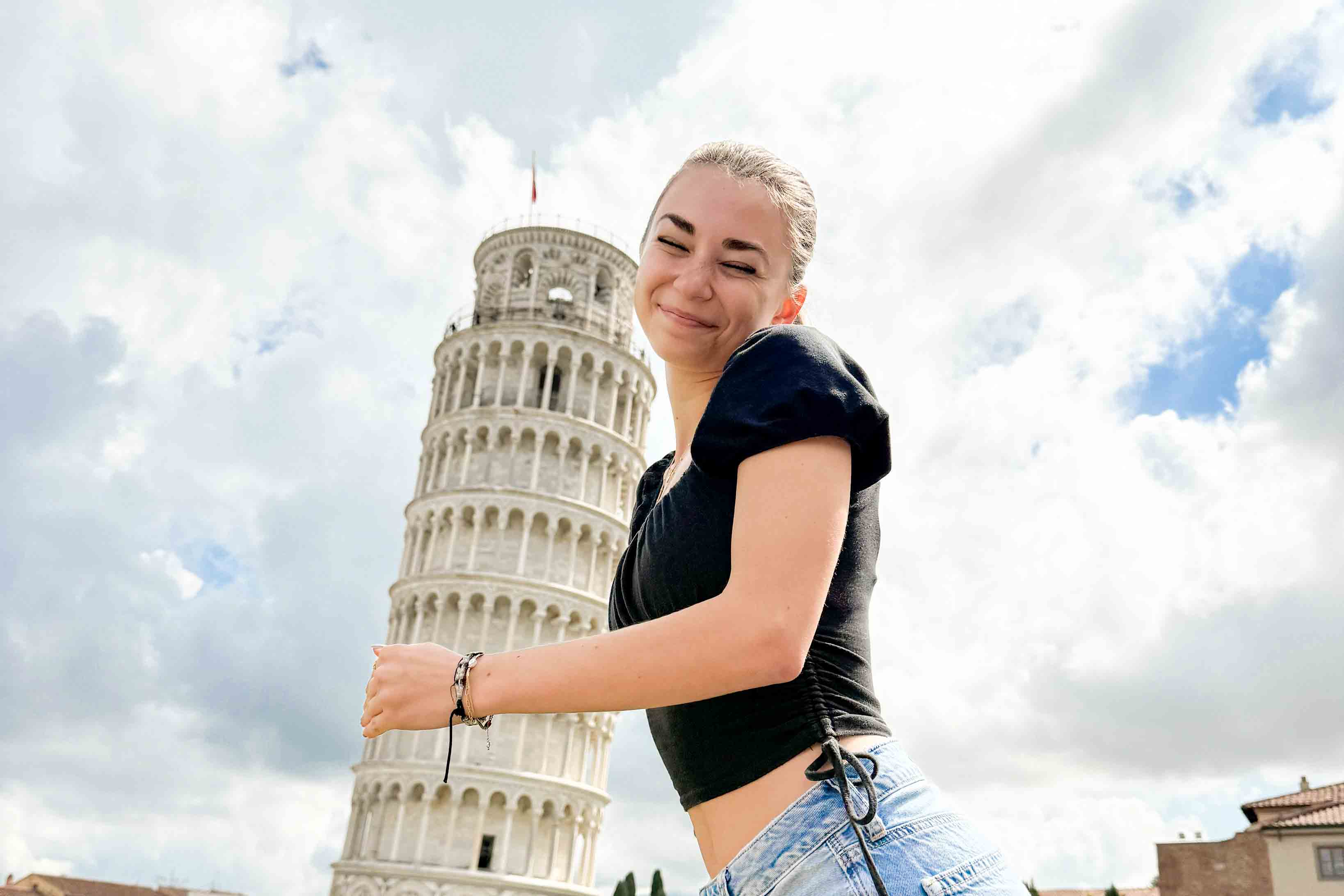 A student appears to be hugging the Leaning Tower of Pisa.