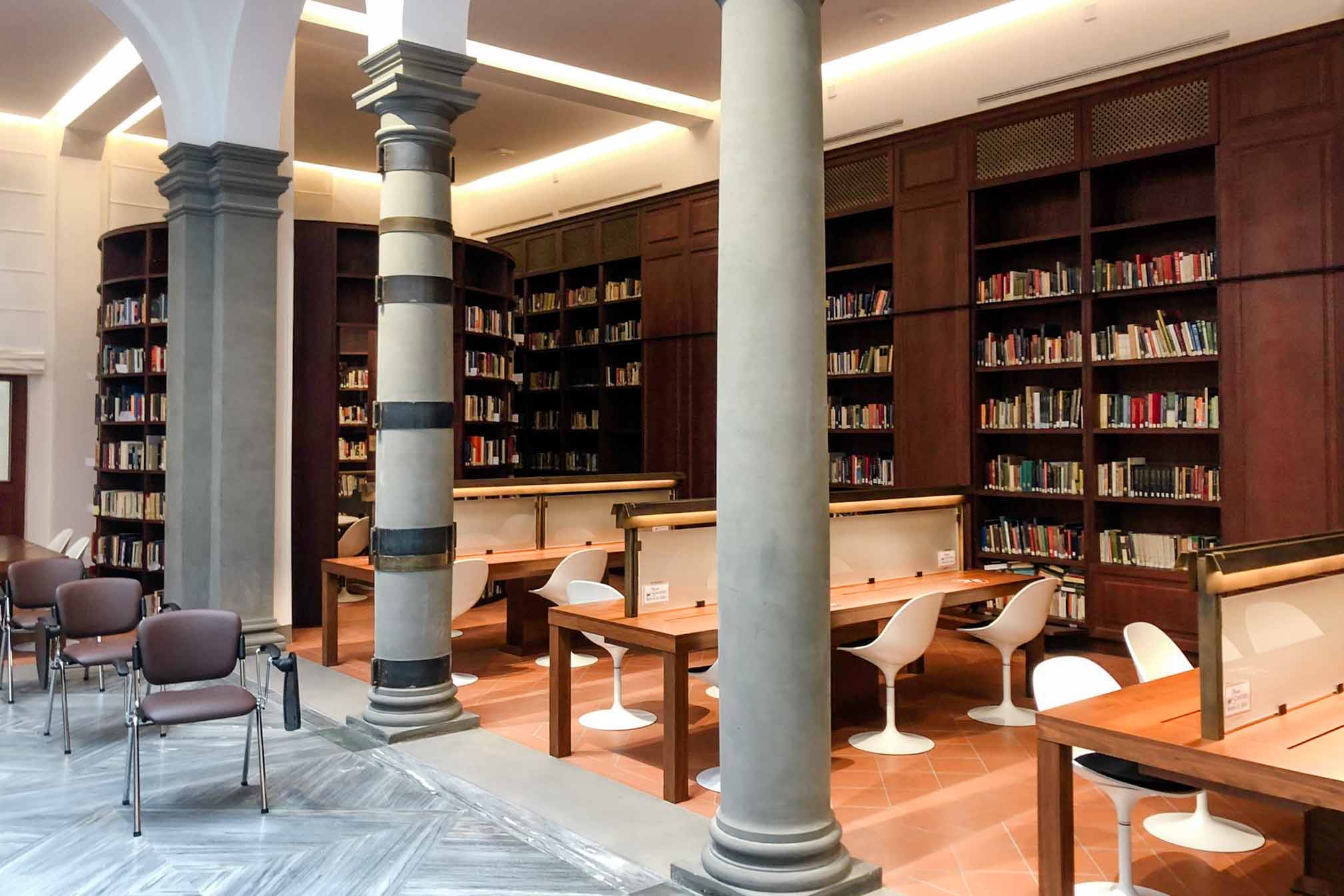 A view of the FSU Florence library, with columns, books, and study desks.