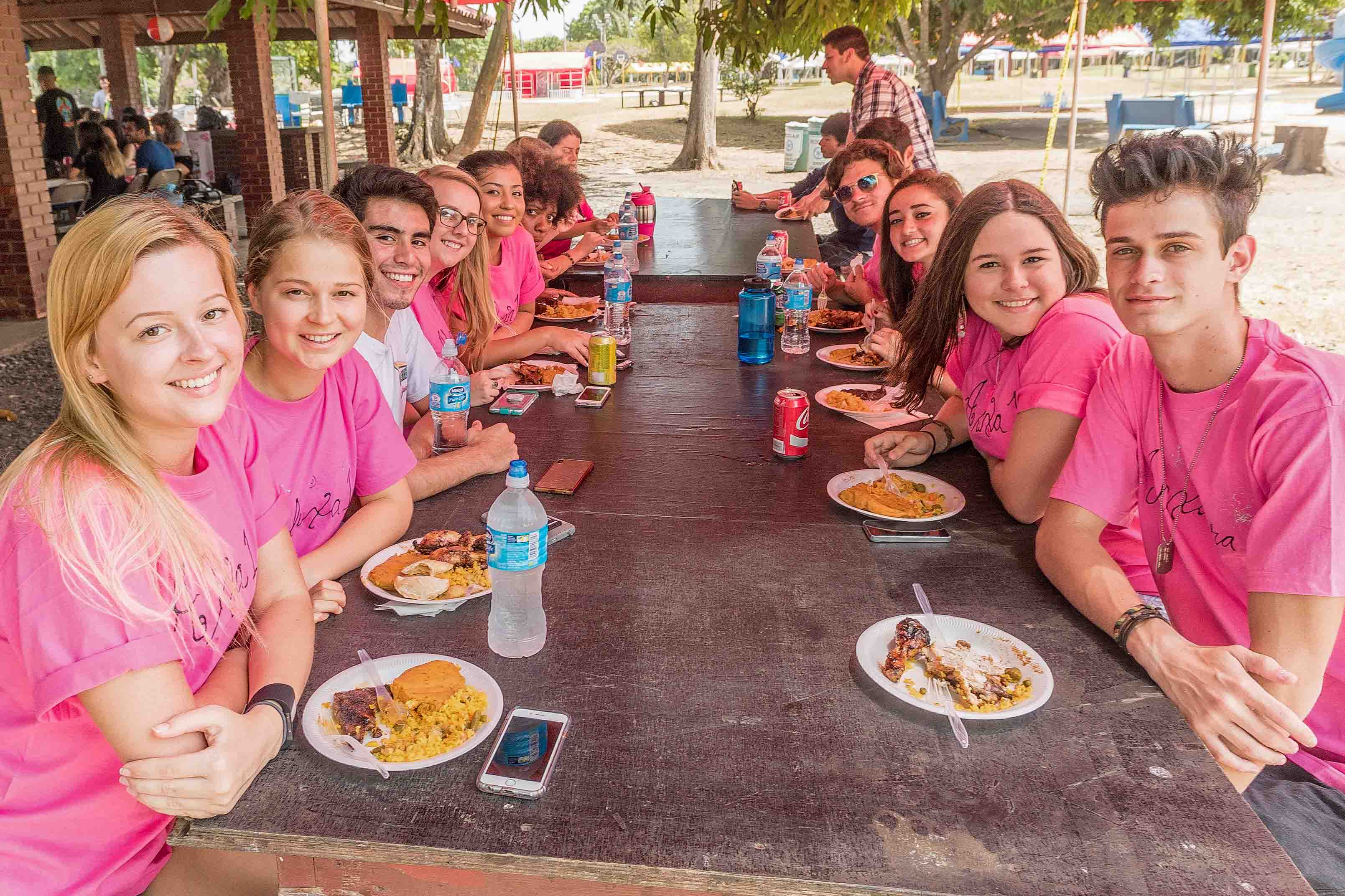 Students sit at a picnic table at an FSU Panama cookout.