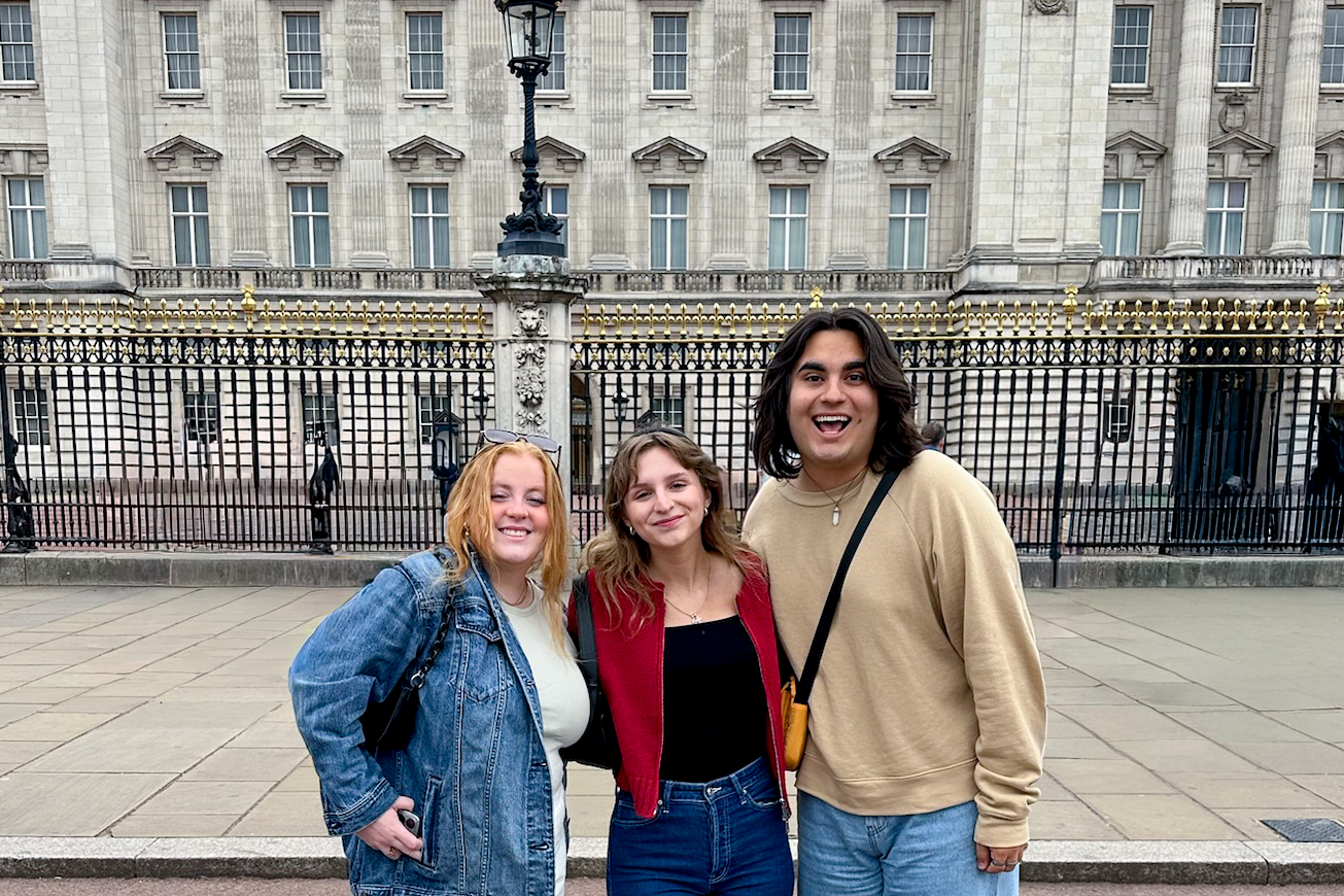 Students posing together in London in front of Buckingham Palace.