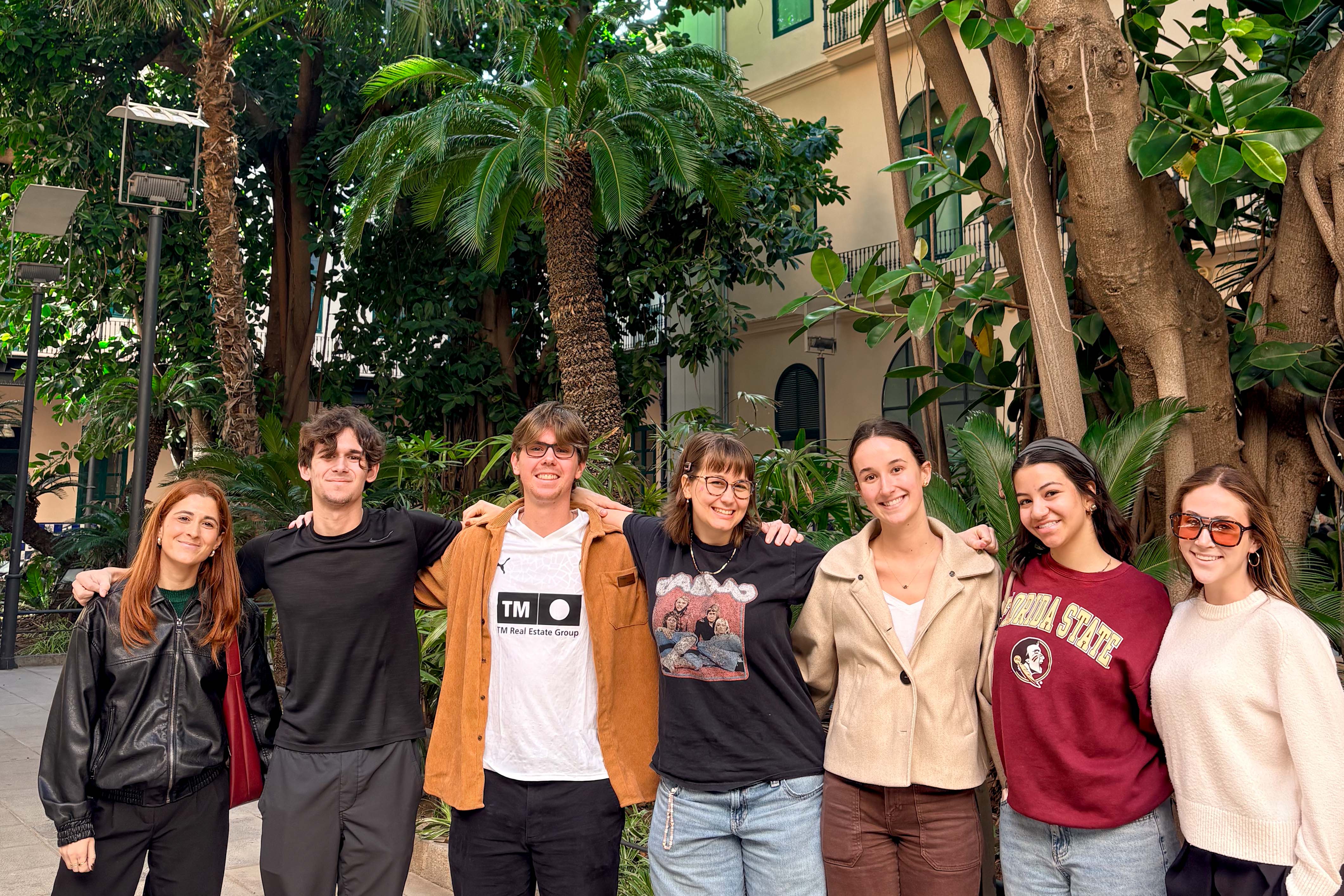 Students posing together in Valencia with green foliage behind them.