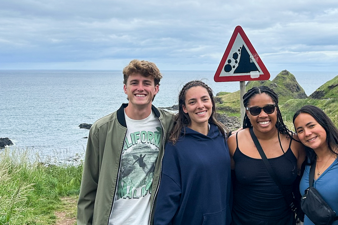Students posing together by the sea.