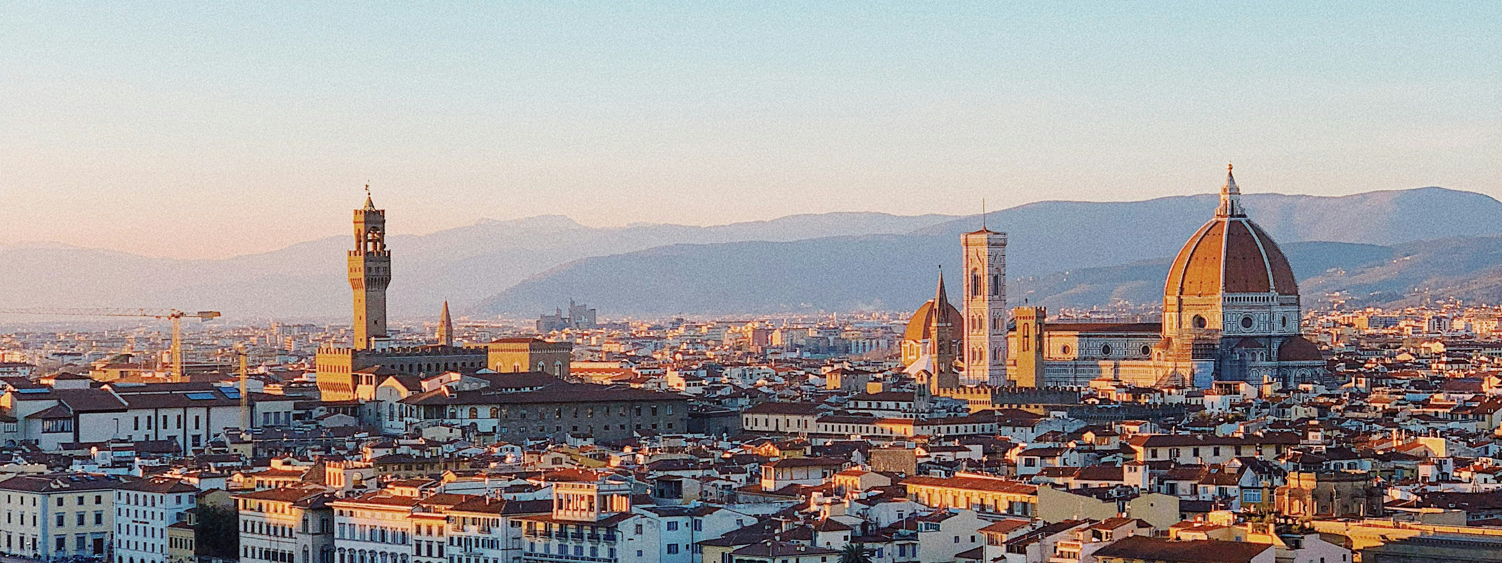 The Duomo with the Arno River in the foreground at sunset.