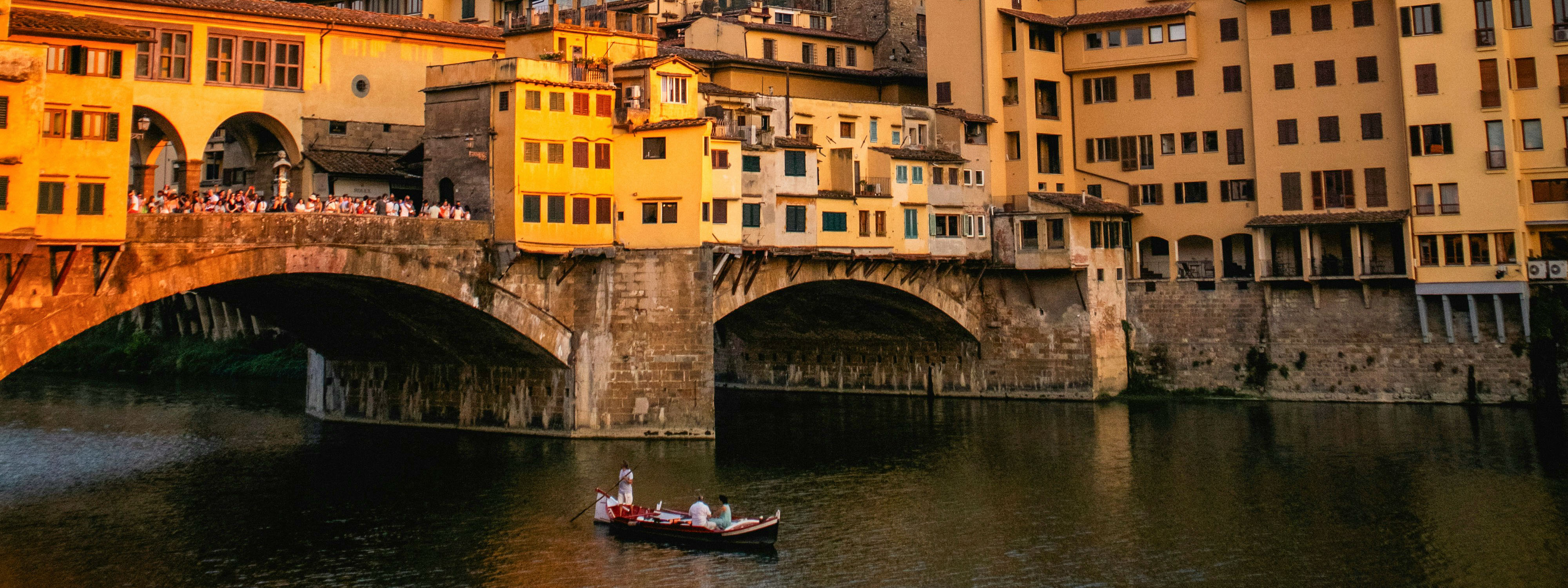 A boat floating by the Ponte Vecchio in Florence.