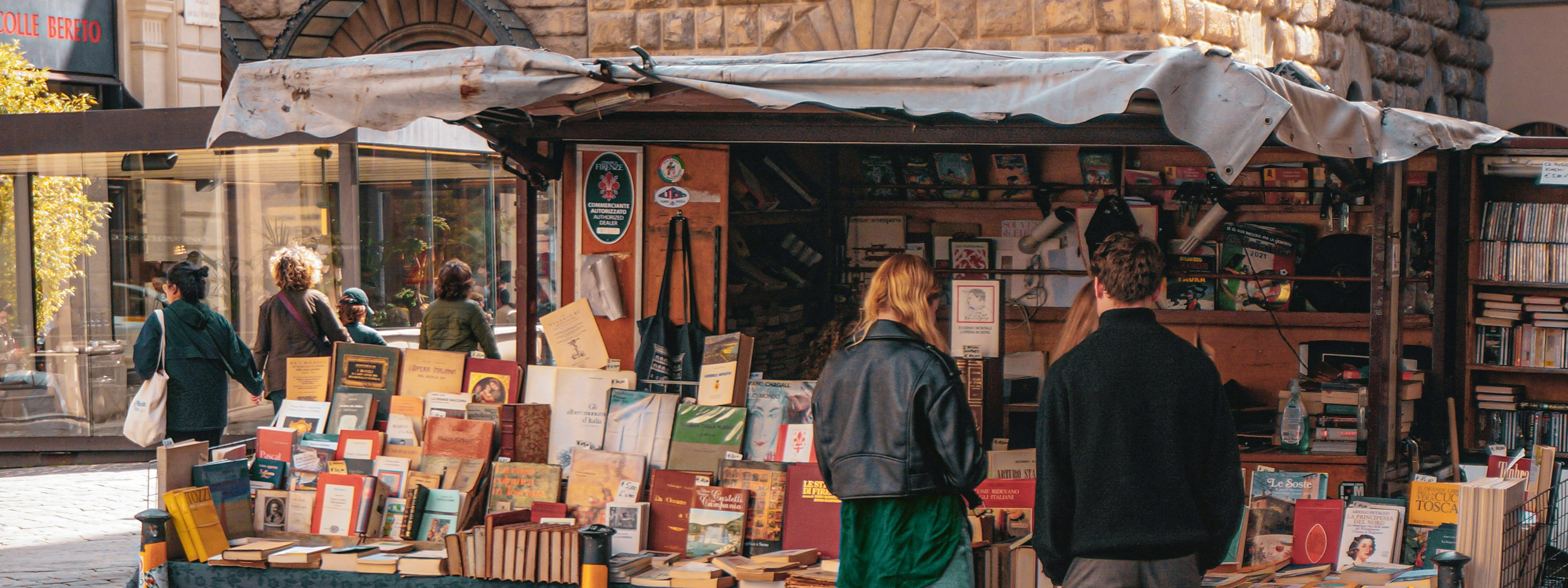 People peruse a book stand in the streets of Florence.