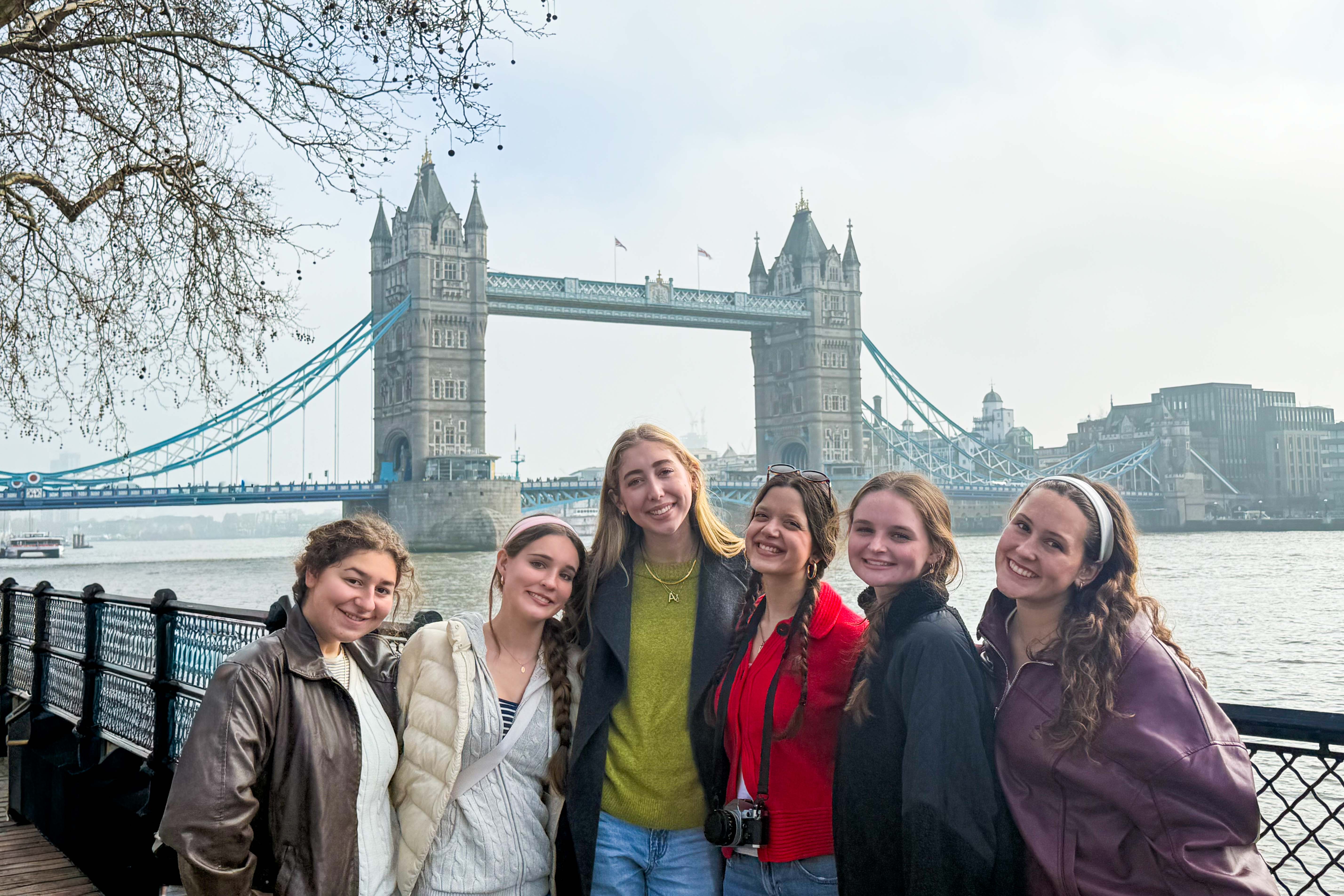 Students posing together in front of Tower Bridge in London.