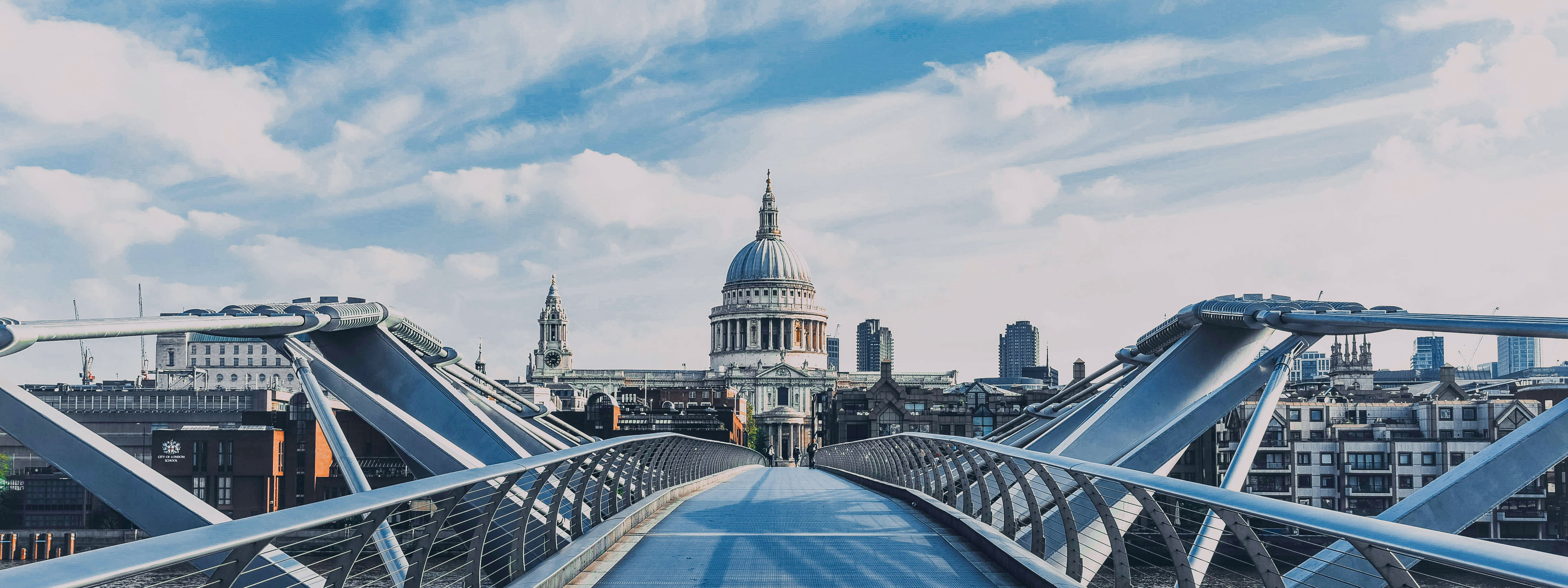 A view of the Millennium Bridge in London in the foreground with St. Paul's Cathedral in the distance.