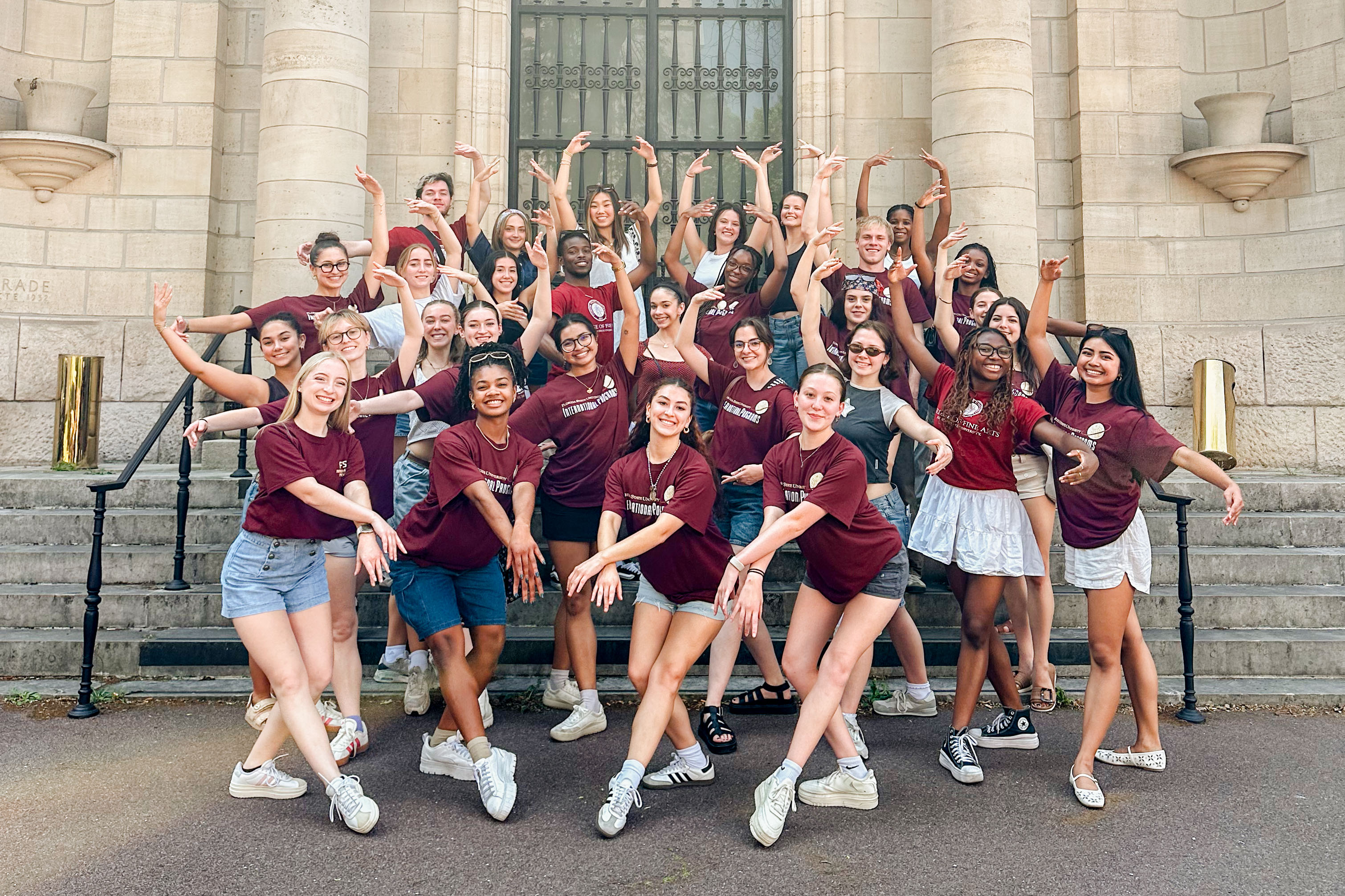 FSU dance students doing ballet poses in front of a historic building in Paris.