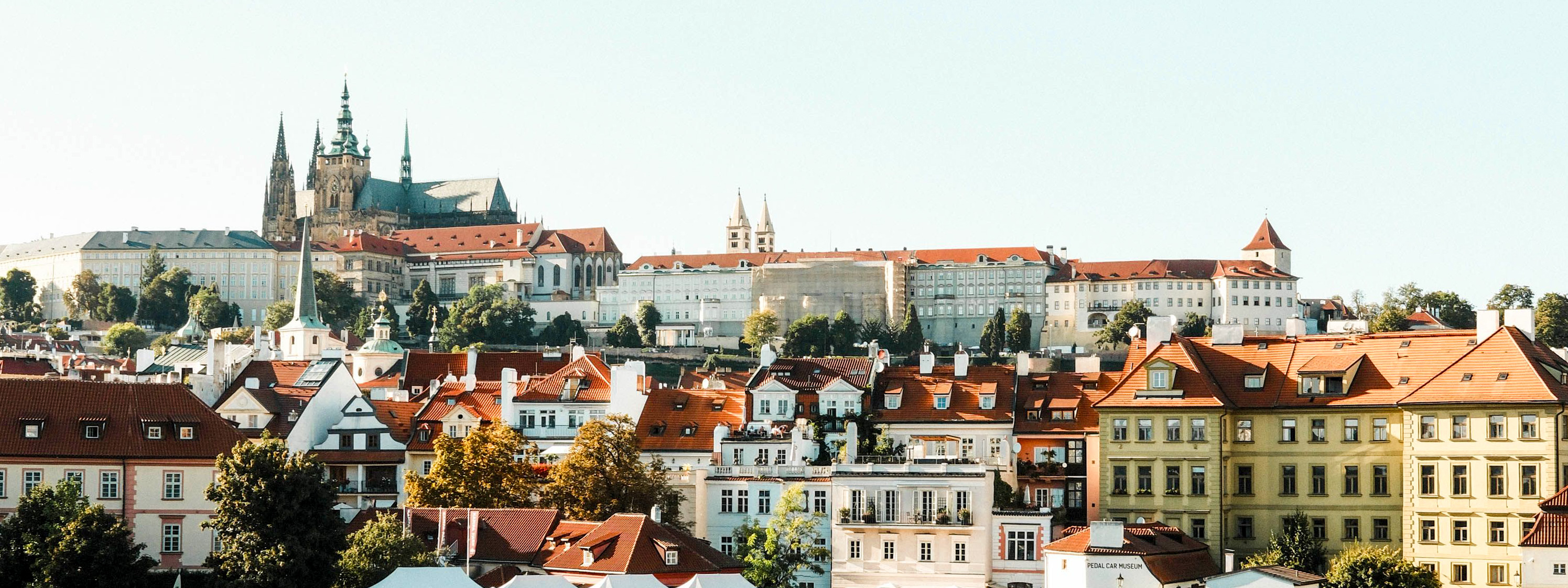 A view of Prague's historic buildings with water and a boat in the foreground. 