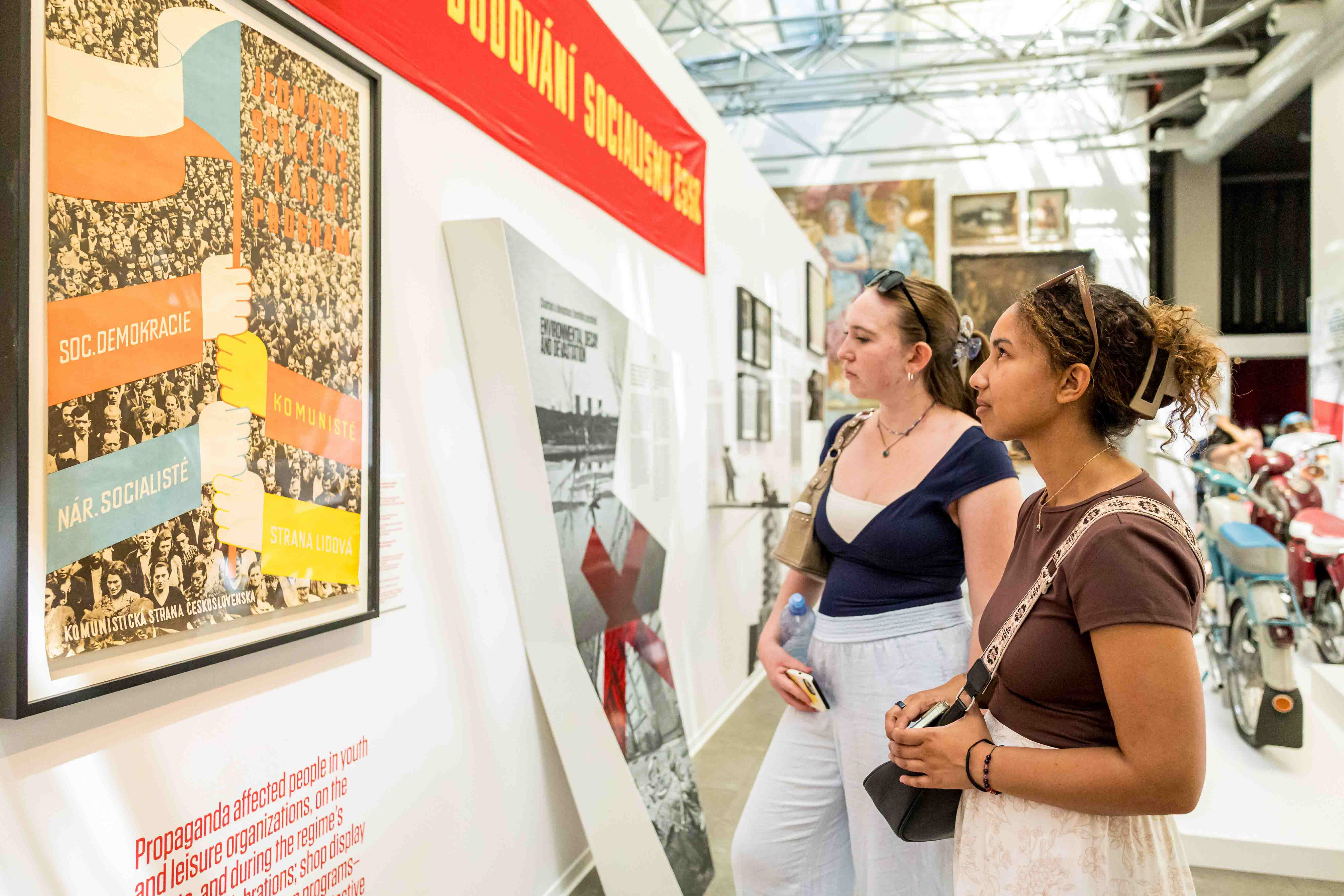 Students observing a poster in a museum exhibit in Prague