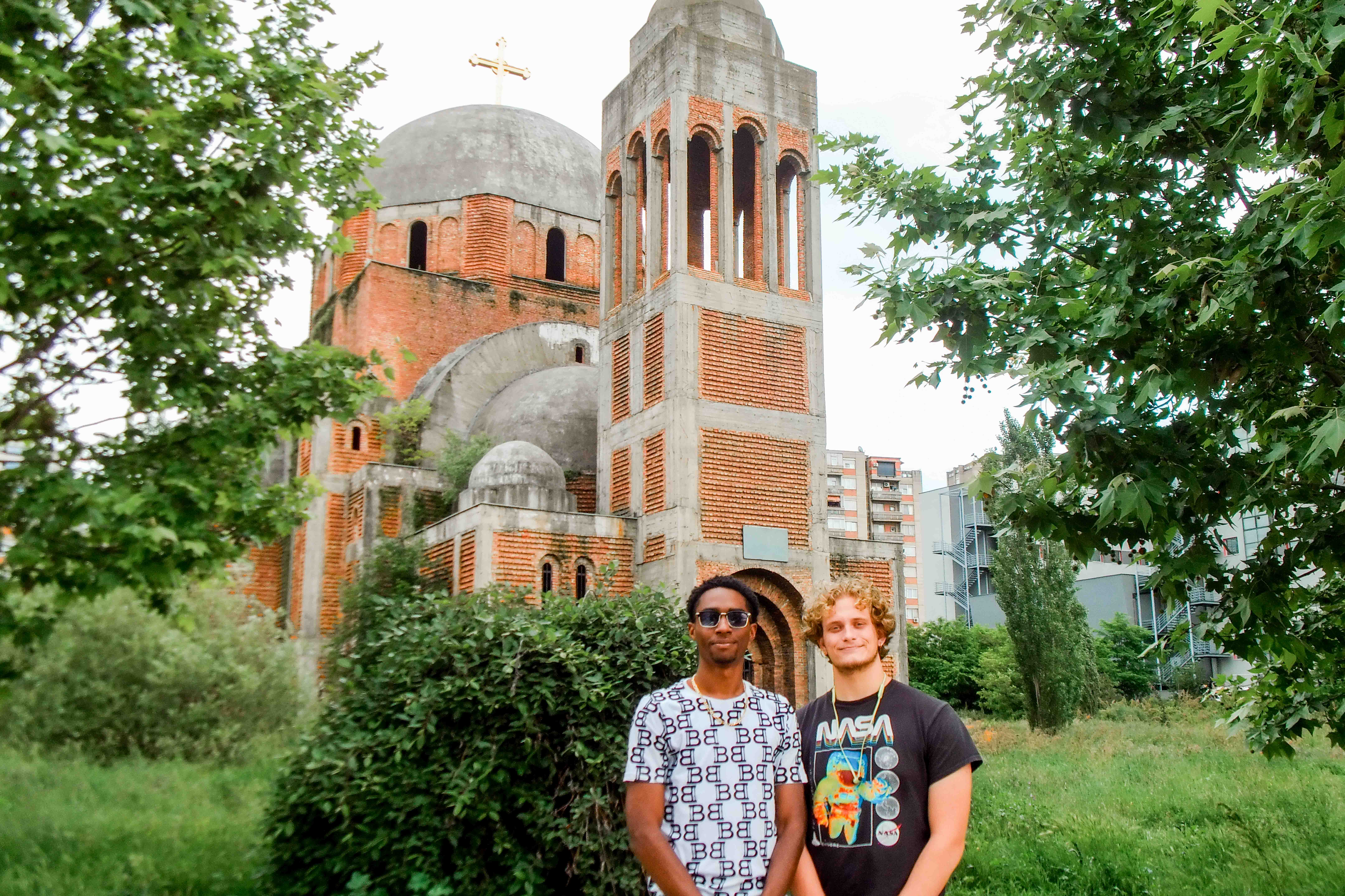Students posing in front of a religious building in Kosovo.