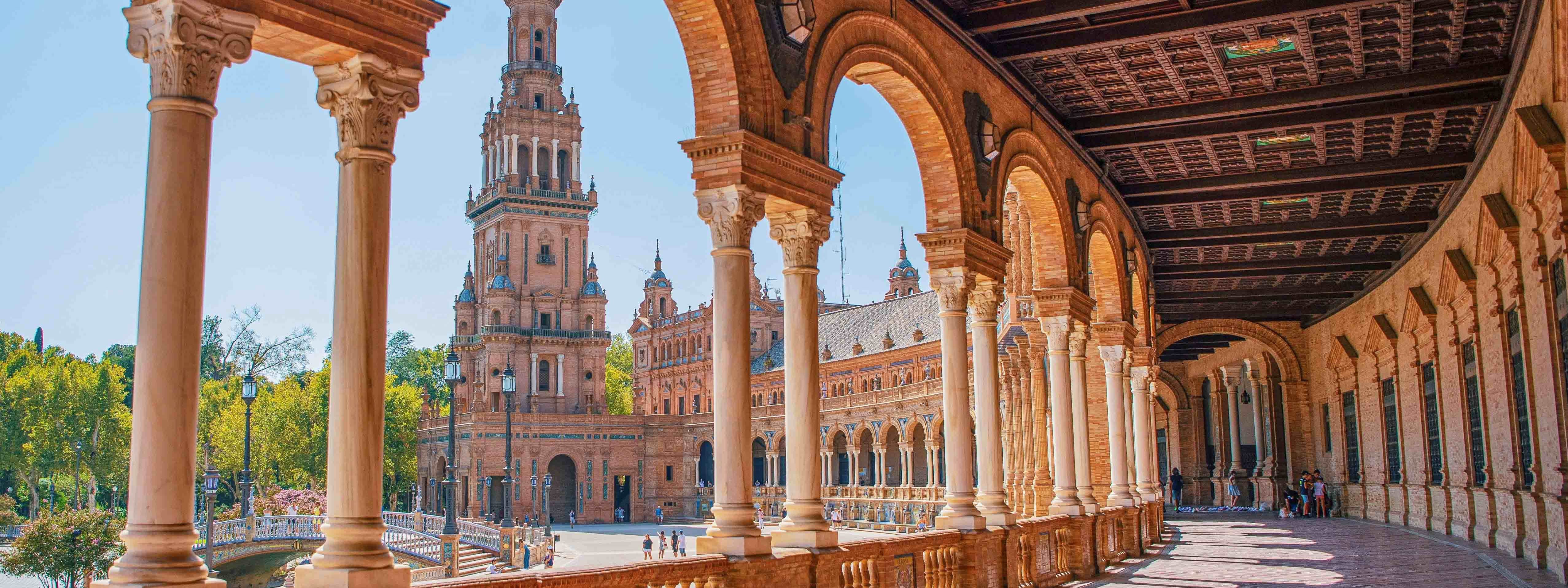 A view of a historic walkway with arches in Seville. 