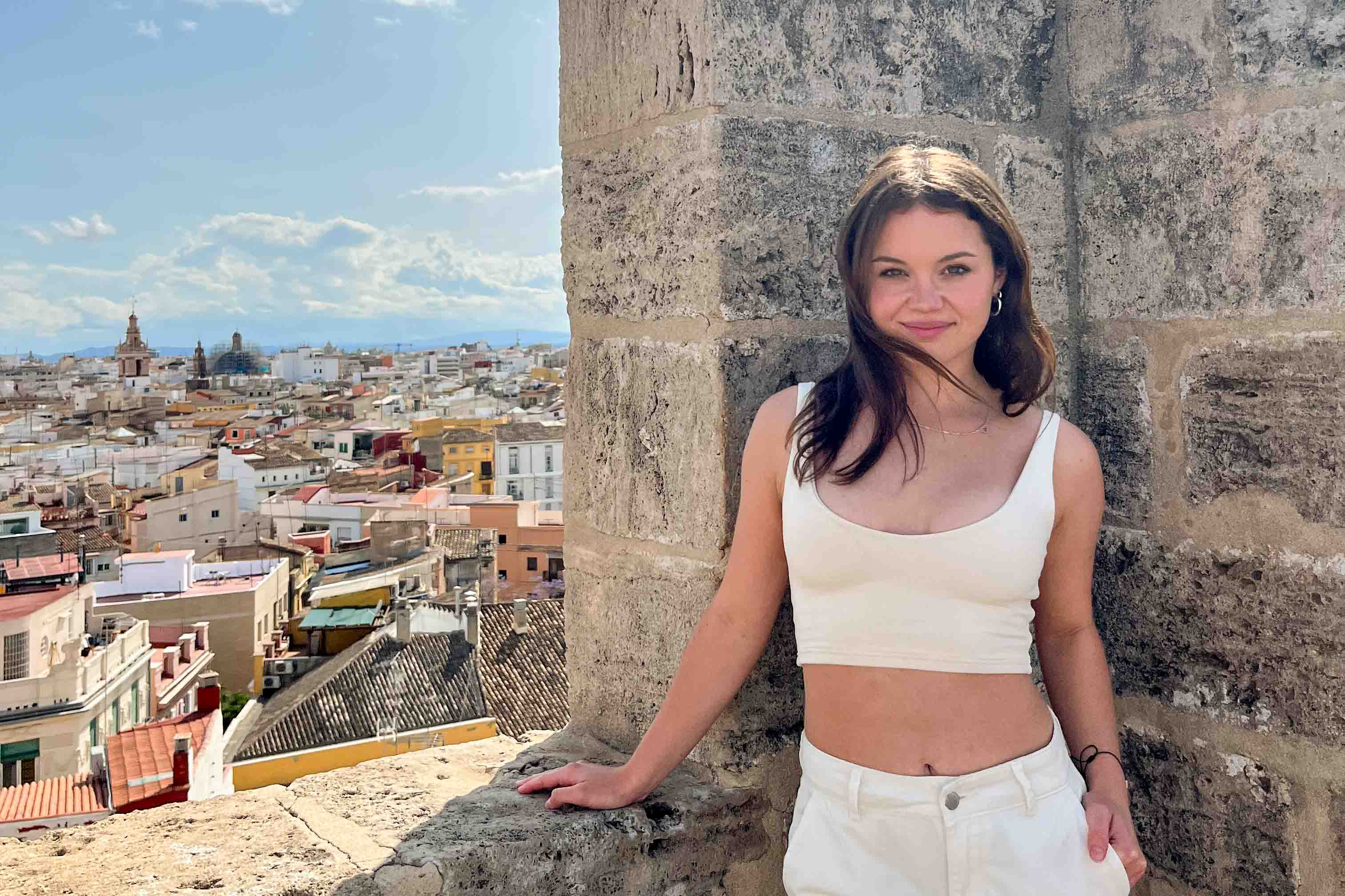 A student in Valencia atop the Serrano Towers with views of the city behind her.