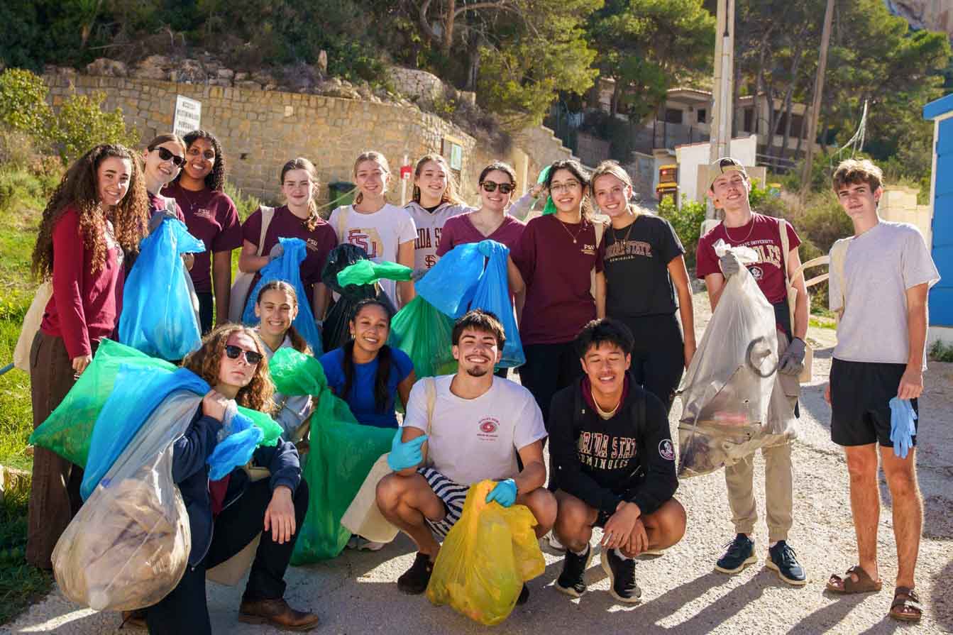 Students volunteering by cleaning up trash from streets and nature areas in Valencia.