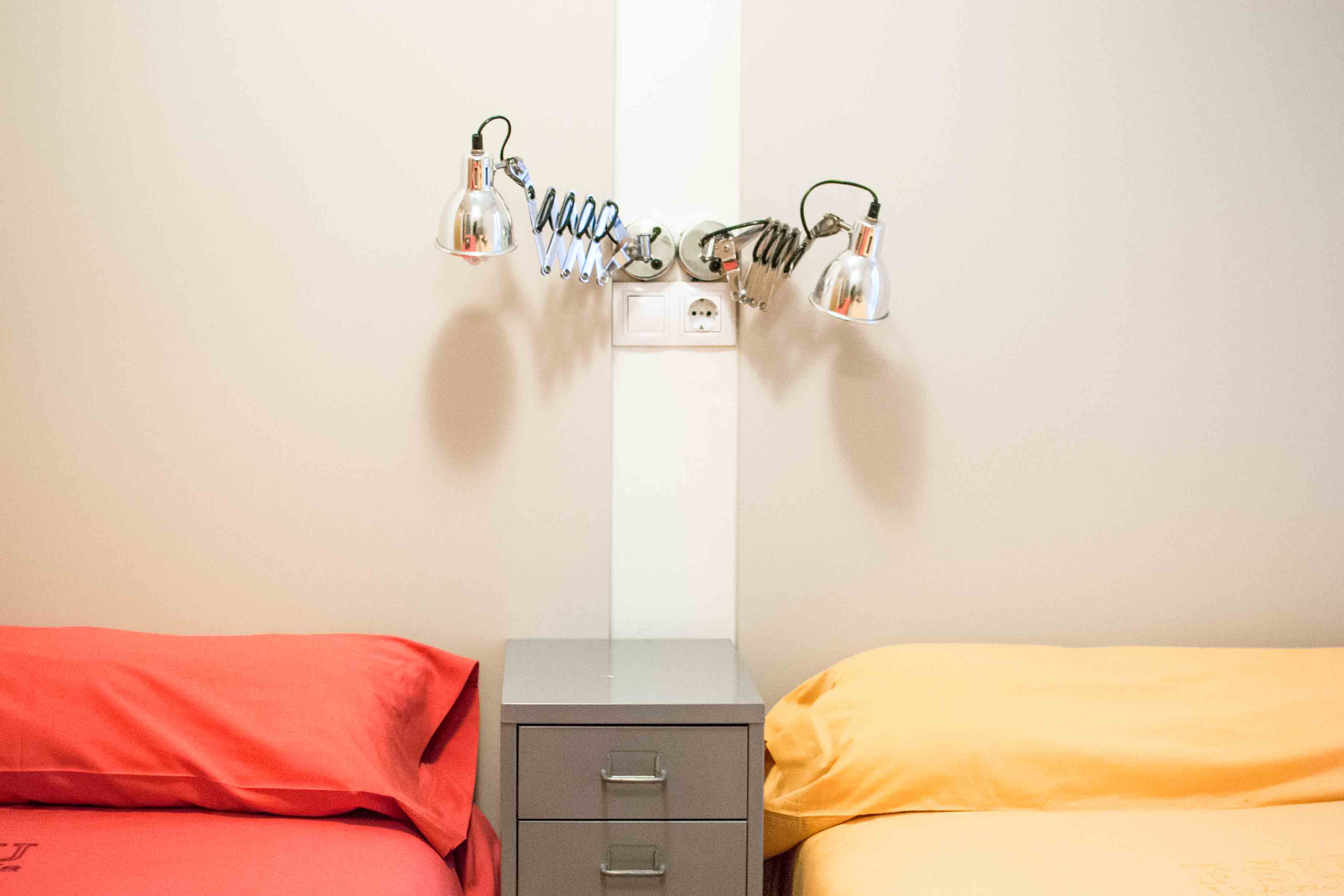 A two beds near each other with reading lamps on the wall at the FSU Valencia housing.