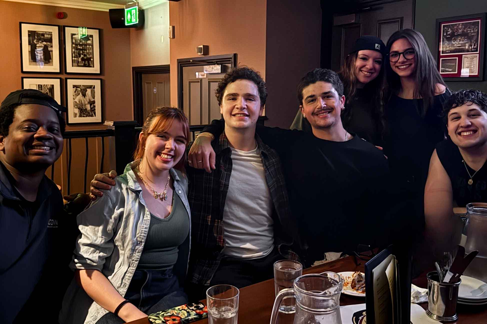 Students pose together around a table in a London pub at an FSU football watch party.
