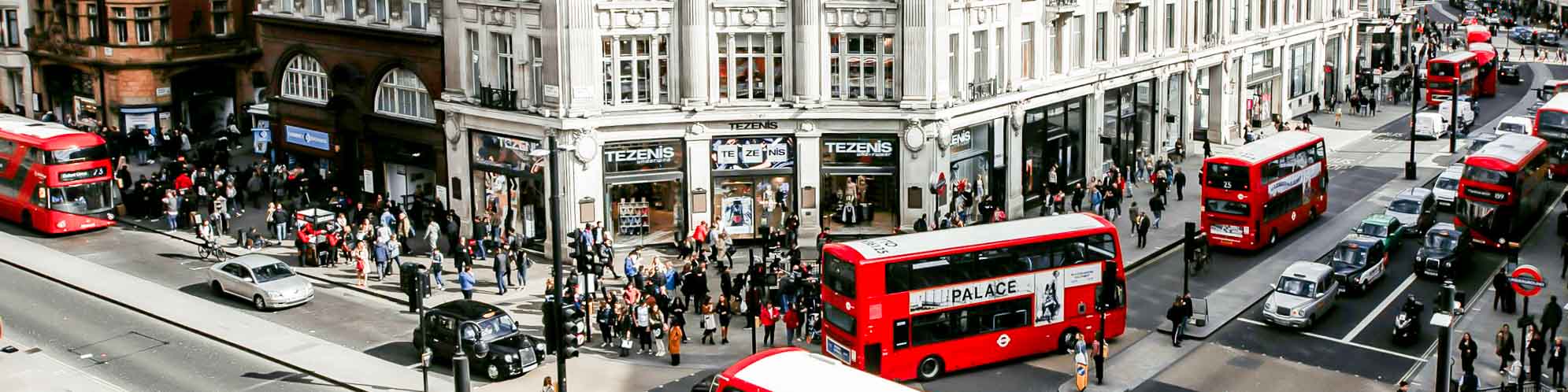 An aerial photo of double decker red buses and taxis driving in London.