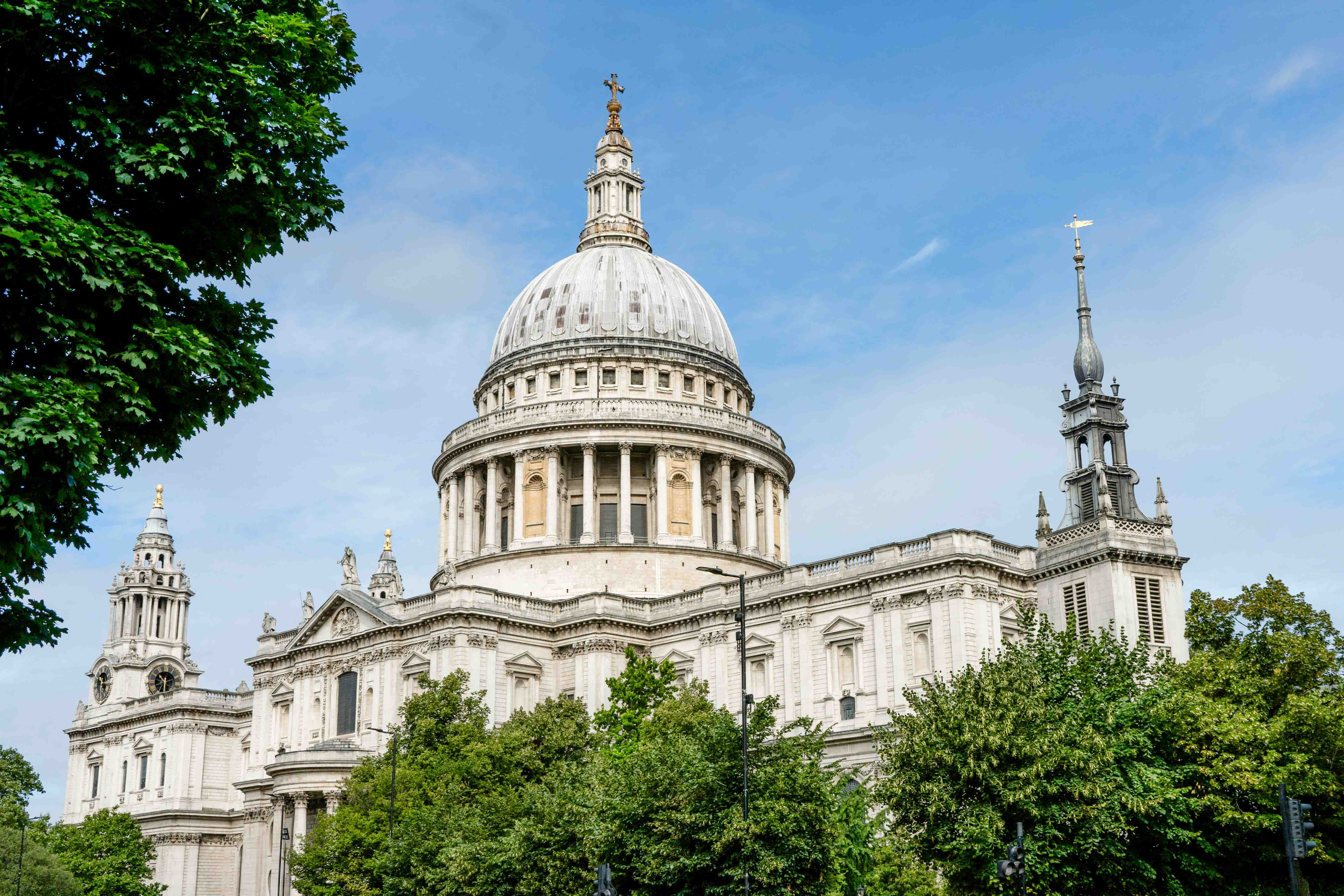 The dome of St. Paul's Cathedral peaks out from behind lush summer trees.