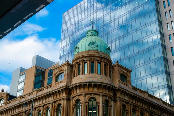 A view of a modern building against a historic building in Belfast. 