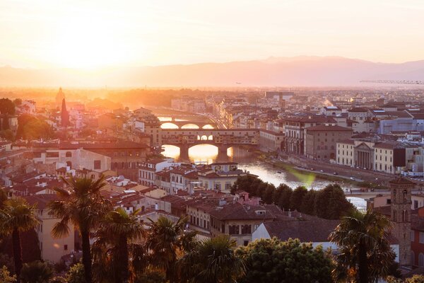 A view of the Ponte Vecchio and Arno River in Florence at sunset.