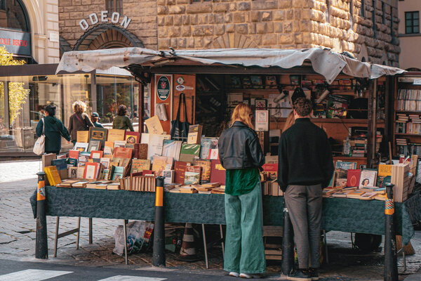 Tourists look through books in a market stand in Florence.