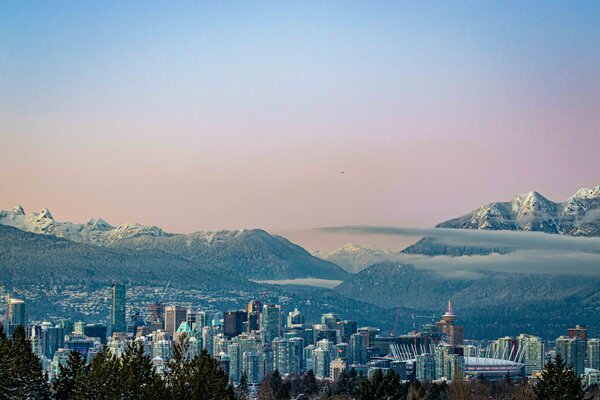 A view of the cityscape in Vancouver with mountains in the background.