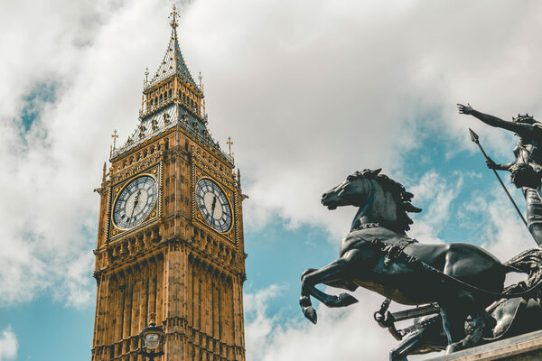A view of Big Ben with a horse statue in front. 