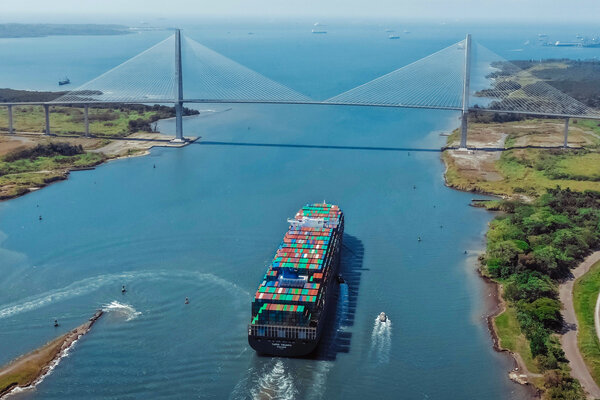 A ship in the Panama Canal approaching a bridge. 
