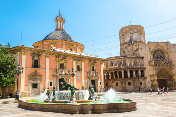 A view of the Plaza de la Virgen in Valencia with a fountain in the foreground. 