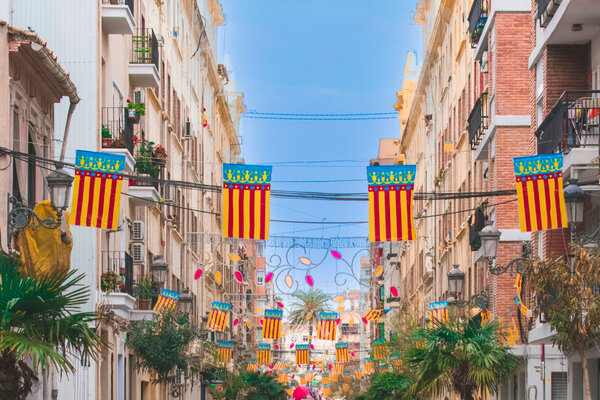 Flags hanging over a street in Valencia during Fallas festival.