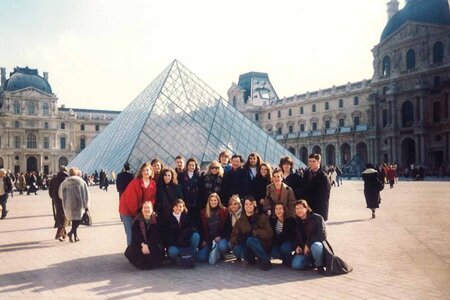 A group of students pose in front of the Louvre in Paris.